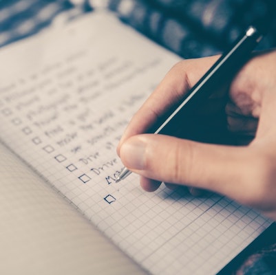 Writing a checklist in a graphing notebook.