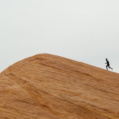 Jogger crests a rocky mountain.